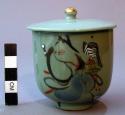 Bluish green covered porcelain tea cup and lid with painted decorations