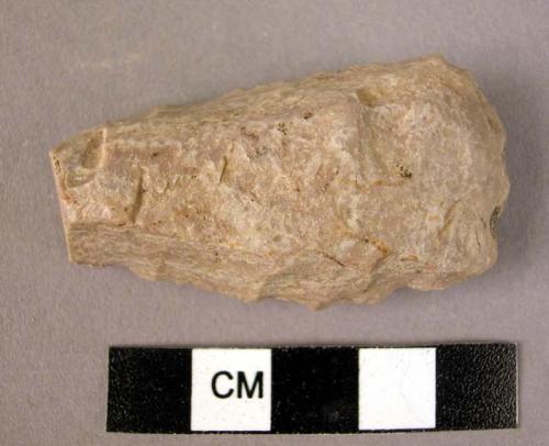 Small chipped stone celt or chisel, partially polished along upper edge