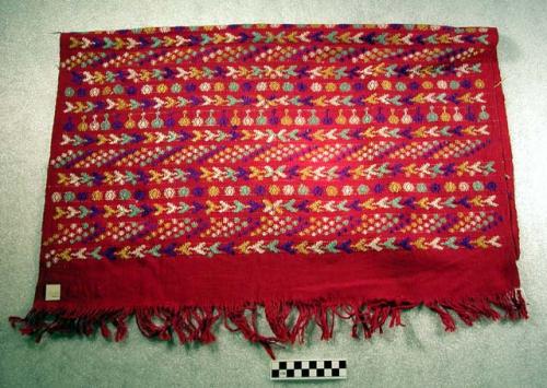 Tzute. red background, embroidered design in blues, yellow, and white. 81 x 68 c