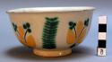 Small glazed bowl on .8 cm. high ring foot--with vegetal motif in yellow and gre
