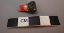 Ceramic, sherd, painted red, gold, black, irregularly shaped