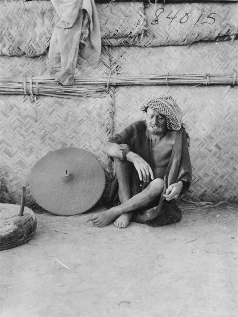 Portrait of a Marsh Arab man from the Khazal area with unidentified object