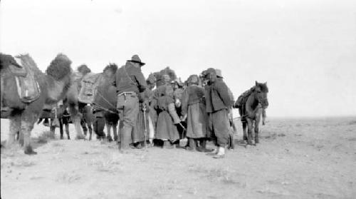 People with camels and ponies in desert