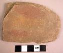 Fragment of stone hoe showing paint stripes of red and yellow