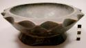 Carved wooden bowl with scalloped edges, base rim pierced by two holes for hangi