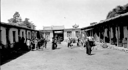 People and cart in road by buildings