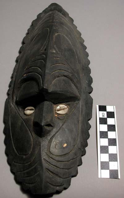 Carved polychrome painted (white, black, orange, red) mask with cowrie shell "ey