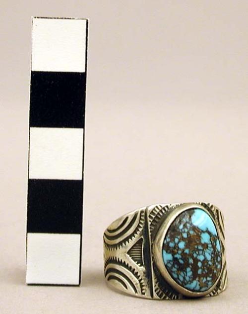 Silver ring w/ one turquoise stone, sides & ring platform have stamped designs