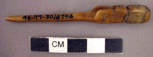 Small bone needle with carved figure on top