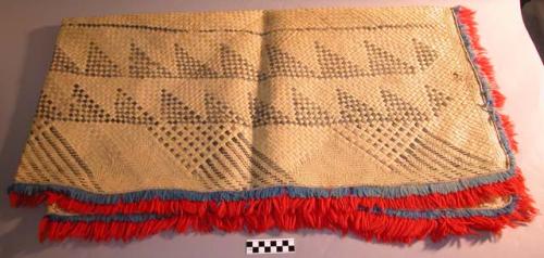 Woven mat, screw pine leaf.  Fringed with red & blue worsted.