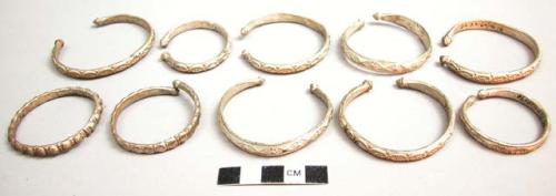 10 small (crescent) bracelets of white metal; Metal bracelets
