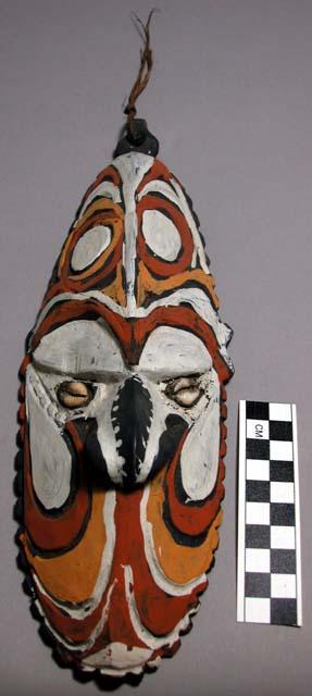 Carved polychrome painted (white, black, orange, red) mask with cowrie shell "ey