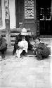 Woman sitting with children by doorway