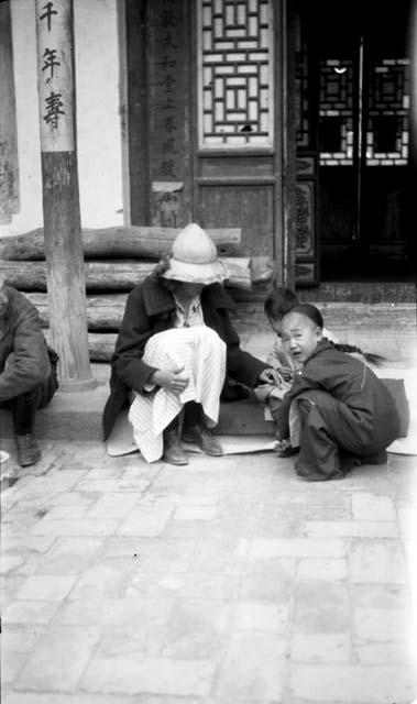 Woman sitting with children by doorway