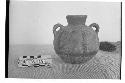 Small pottery jar with two vert. loop handles. Flat base, flattened rim, round l