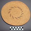 Mat, round, flat, woven vegetable fiber, brown rays interwoven at surface
