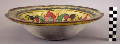 Ceramic dish with polychrome designs on interior, mended, cracks along rim