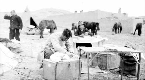 People setting up desks and tents in desert