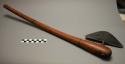 Axe; carved, curved wood handle; triangular metal blade; wear at tips