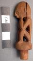 Carved wooden stopper in shape of sitting man with hands on face, for small bott