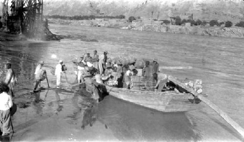 Men in and beside boat in river