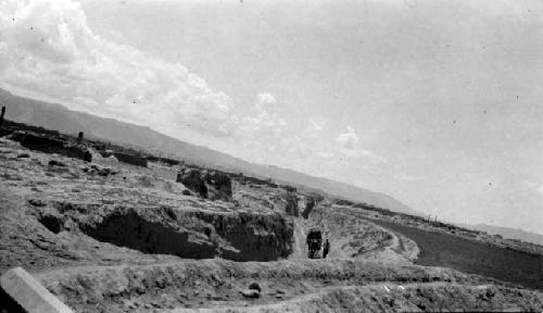 Person on dirt road, mountains in distance