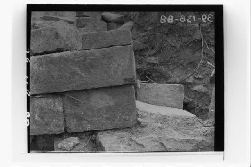 Corner of N. front wall of Temple; stones and plaster of terrace floor.