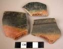 8 potsherds - black and red ware; 2 showing incisions, possibly of "pot-marks"