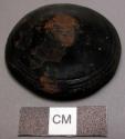 Ornament, leather covered object, squat conical, impressed circumference, worn