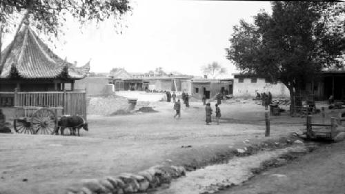 People and buildings, ox with cart outside