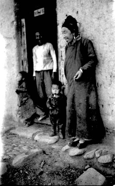 People and children standing by doorway of building