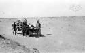 People leading oxen pulling cart