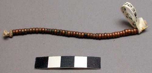 Woman's earring of copper beads on string