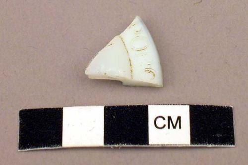 Glass fragment, white, with raised lettering