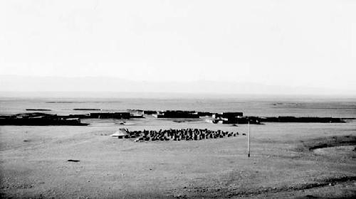 Tent and boxes in desert near buildings