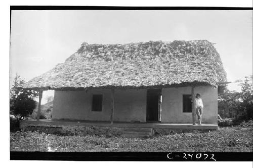 Woman standing on porch of finished Morris house