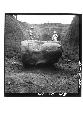 Front view of stone head with laborers behind