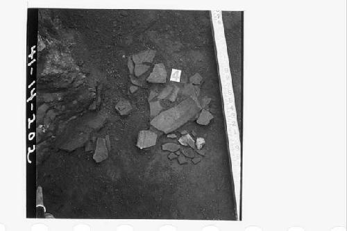 Potsherds on concrete floor in SE cor. of sect. N57.6E partly under stake N56.6E