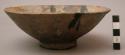 Shallow unglazed ceramic bowl with small pedestal, no design.