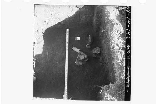 Potsherds 2.7' below level of stake N56.6E in section N57.7E.  From W wall of se