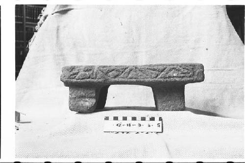 Carved tripodal stone metate