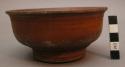 Bowl, turned wood, reddish stain, pedestal base, perforated, flared rim