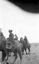 Woman and men on camels in desert