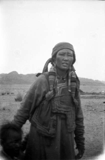 Woman wearing hat standing with child in desert