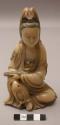 Stone figure of seated woman with beads