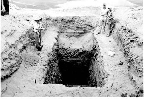 People looking into excavation pit; Marked " Cerro de Trinidad. Looking South a