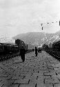 People on walkway, mountains in distance