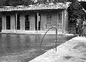 People standing near pool of water, building in background