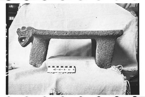 Tripodal metate with ornately carved head at one end