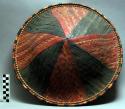 Round basketry hat of alternating red and black panels - Inner headband of +